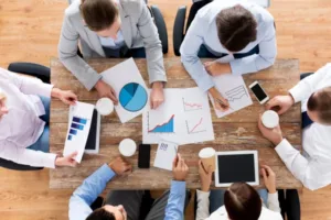 Equipe analisa gráficos e números em reunião de estudo de viabilidade de empreendimento
